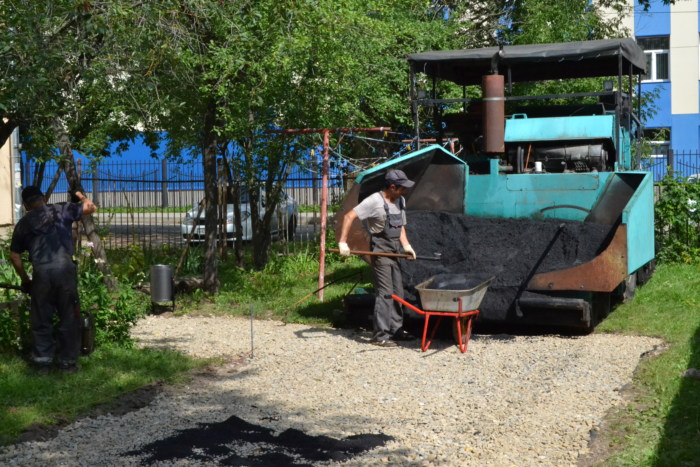 Дорожники укладывают асфальт во дворе доме № 14 на улице Люлина.